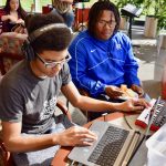 Teens make music using instrument technology.