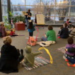 a librarian reads a storybook to a group of children an parents